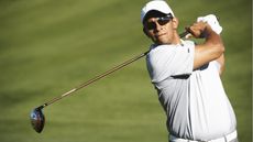 A golfer watches where his ball goes after teeing off.