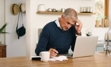 A senior man planning his finance, paying bills and looking unhappy while using laptop at home.