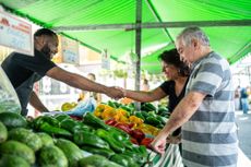 Salesman greeting customers on a street marke