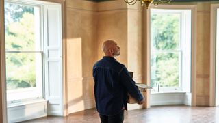 A man carries a box into his new home.